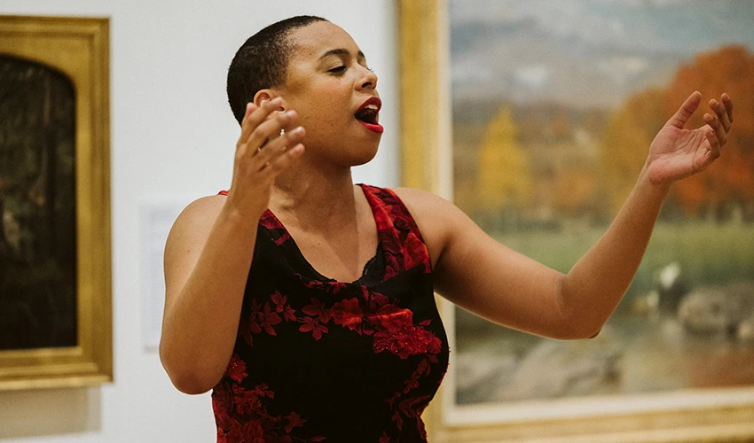 photo of opera singer in red dress singing in museum gallery